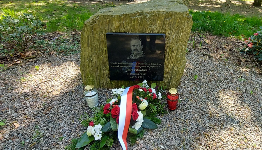 Obelisk Marszałka Józefa Piłsudskiego. Przed obeliskiem kwiaty i znicze
