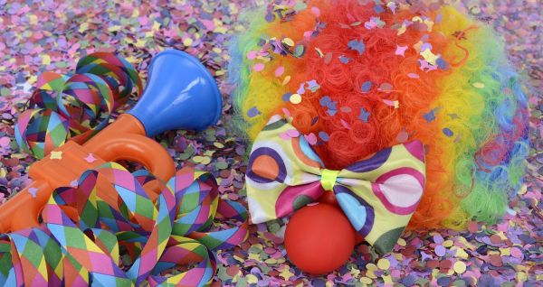 Atrybuty klauna - kolorowa peruka, czerwony nos i plastikowa trąbka