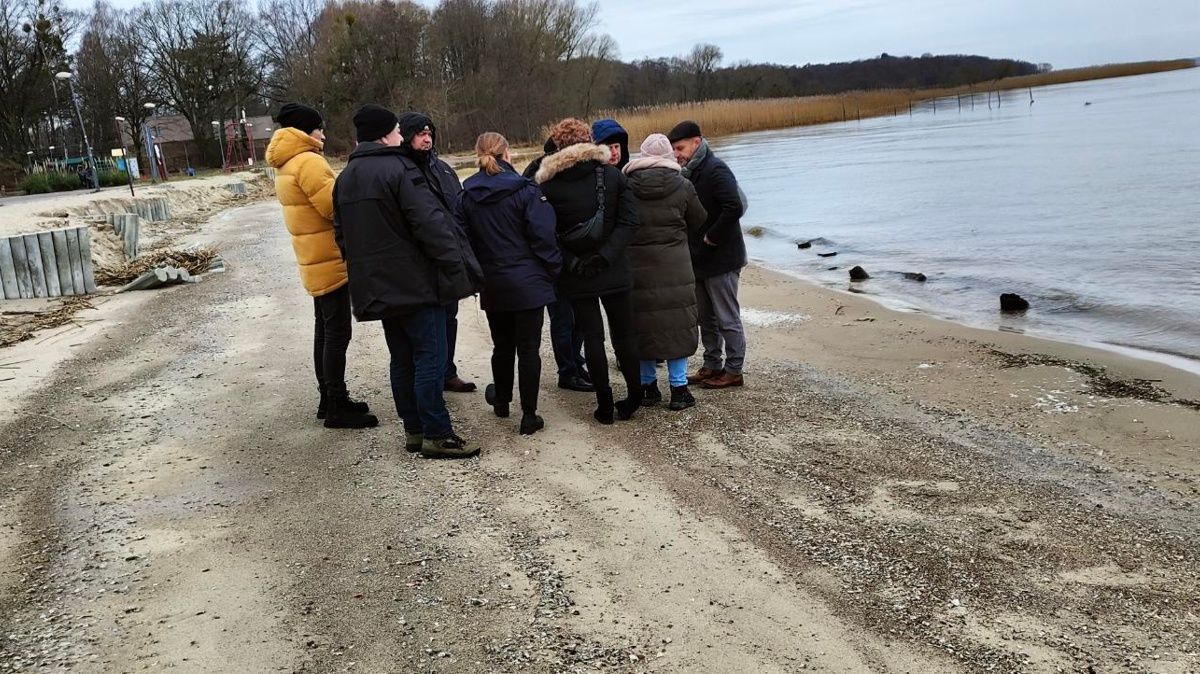 Grupka 9 osób stoi na plaży w Trzebieży