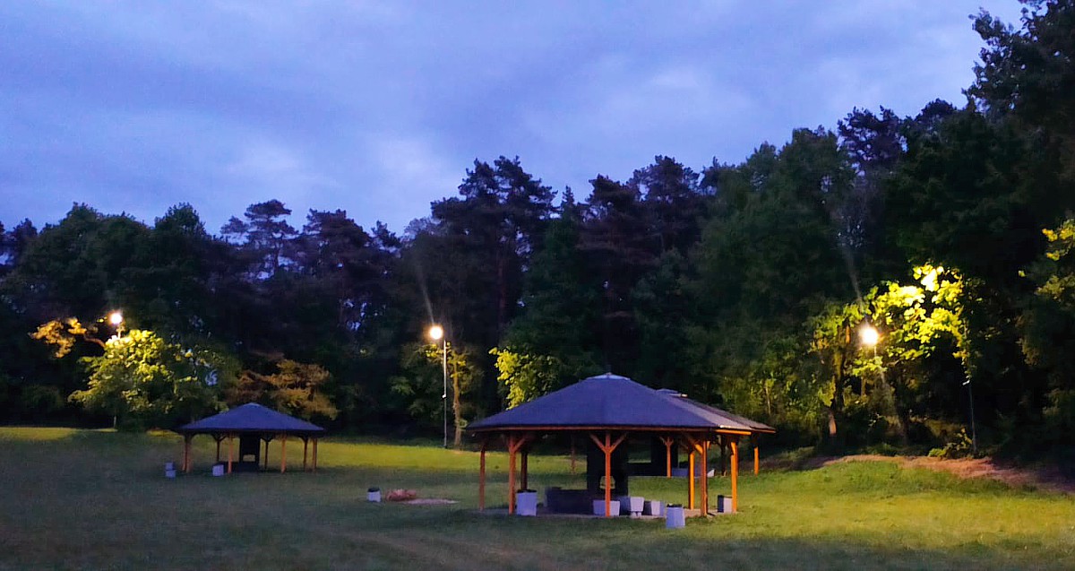 Polana, widoczne wiaty i piknikowe i działające oświetlenie