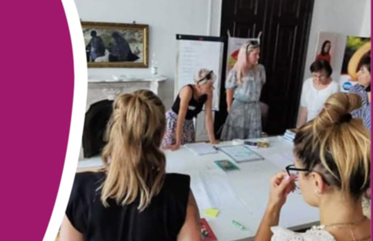 zdjęcie z plakatu - osoby siedzące, stojące wokół stołu