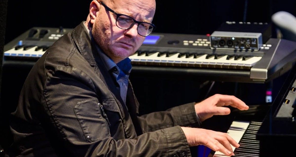 Mężczyzna siedzi i gra na instrumentach klawiszowych