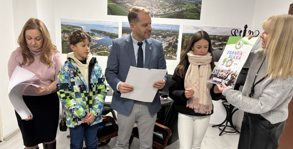 Troje dorosłych i dwoje uczniów - jedna osoba pokazuje kalendarz