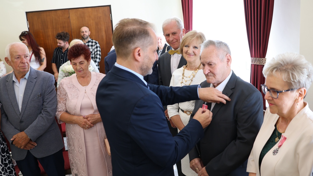 Burmistrz Polic Krystian Kowalewski wręcza medale jubilatom