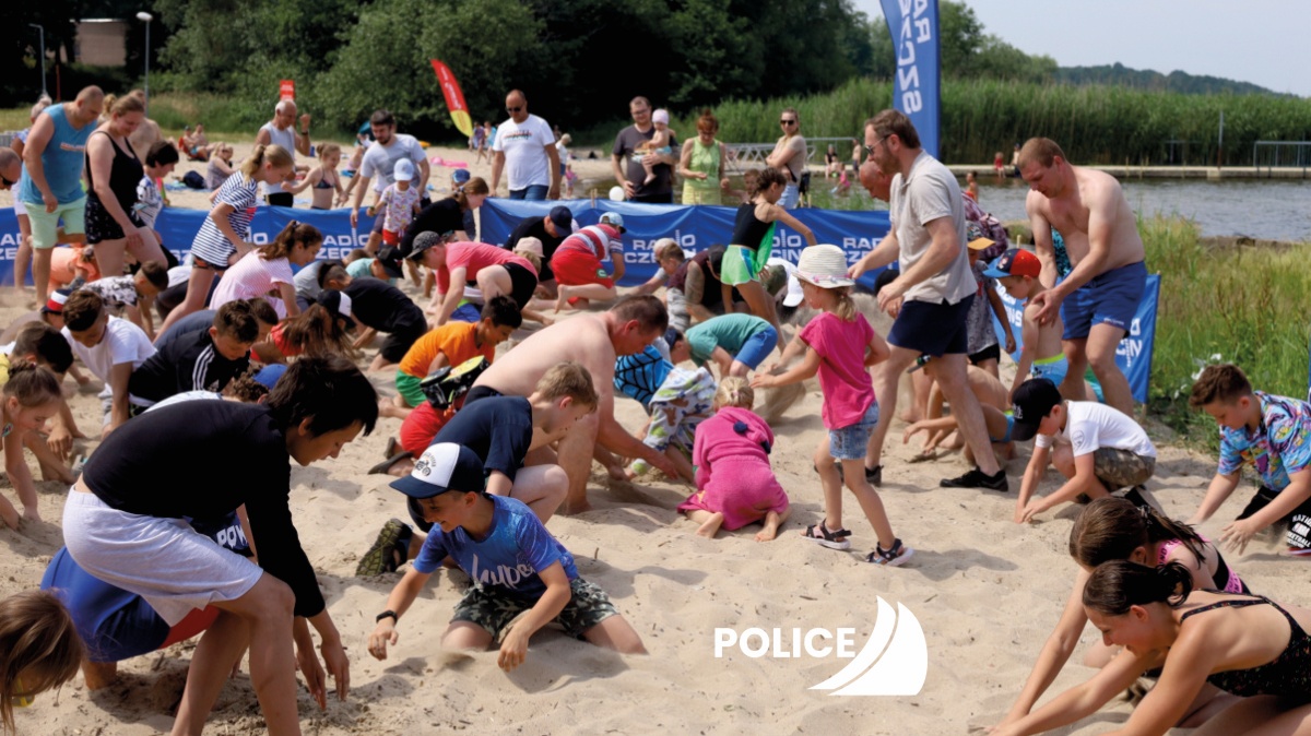 Dzieci i dorośli podczas szukania skarbów zakopanych na plaży w Trzebieży
