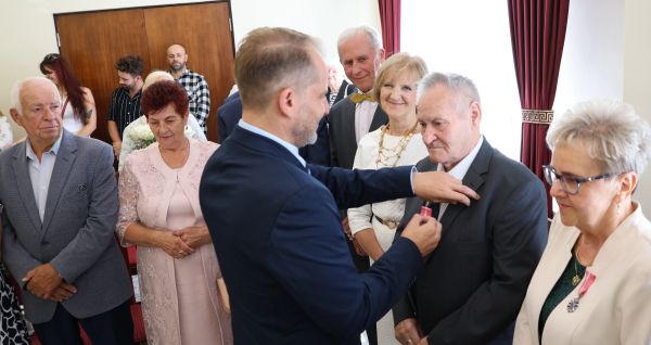 Burmistrz Polic Krystian Kowalewski wręcza medale jubilatom