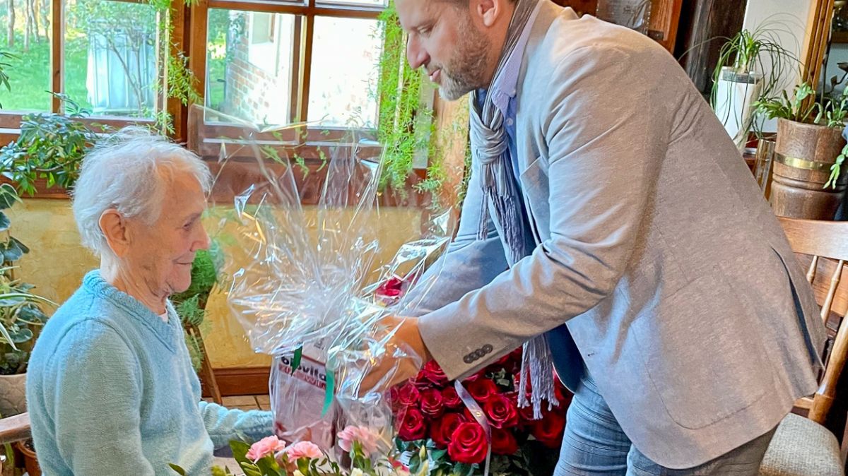 Na zdjęciu: burmistrz Polic Krystian Kowalewski wręcza bukiet kwiatów pani Jadwidze