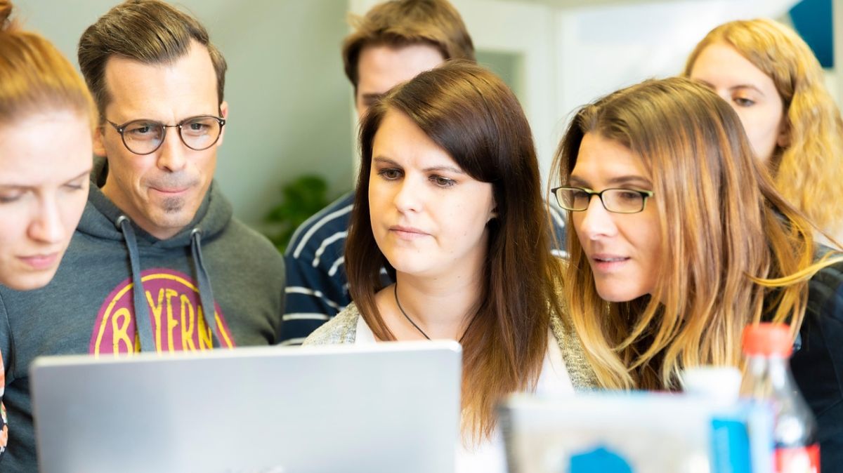 Ilustracja poglądowa - grupka osób wpatruje się w ekran laptopa