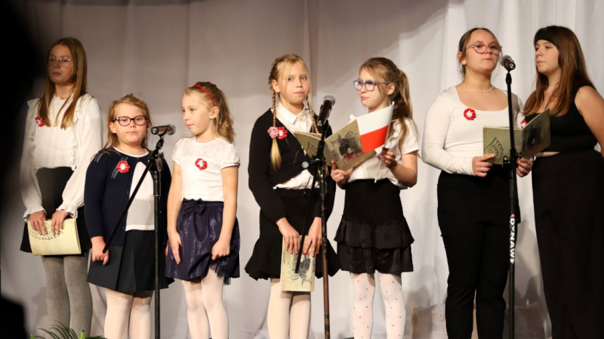Dzieci stoją na scenie i śpiewają