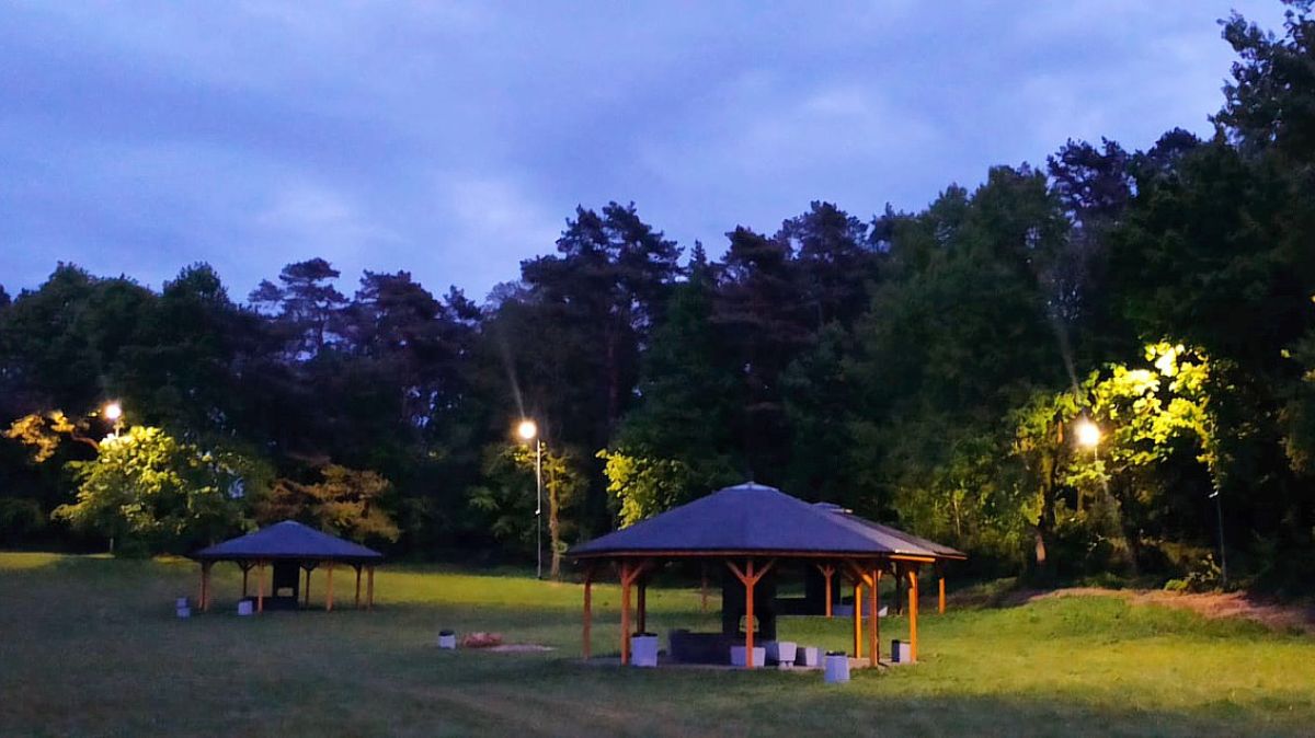 Polana, widoczne wiaty i piknikowe i działające oświetlenie
