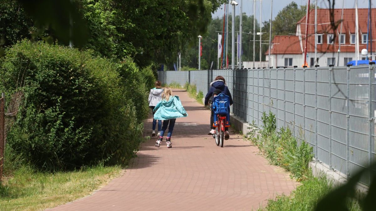 Ścieżka rowerowa, jedna osoba na rowerze a dwie na rolkach