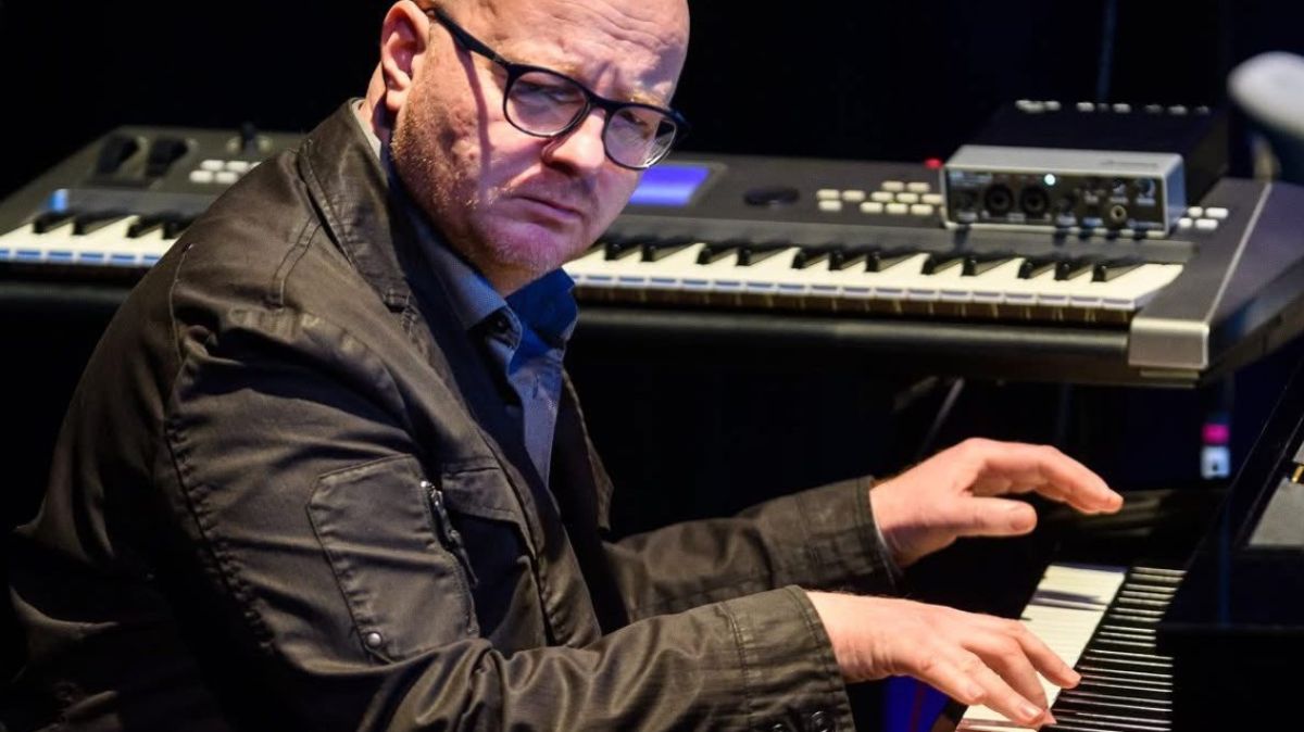 Mężczyzna siedzi i gra na instrumentach klawiszowych