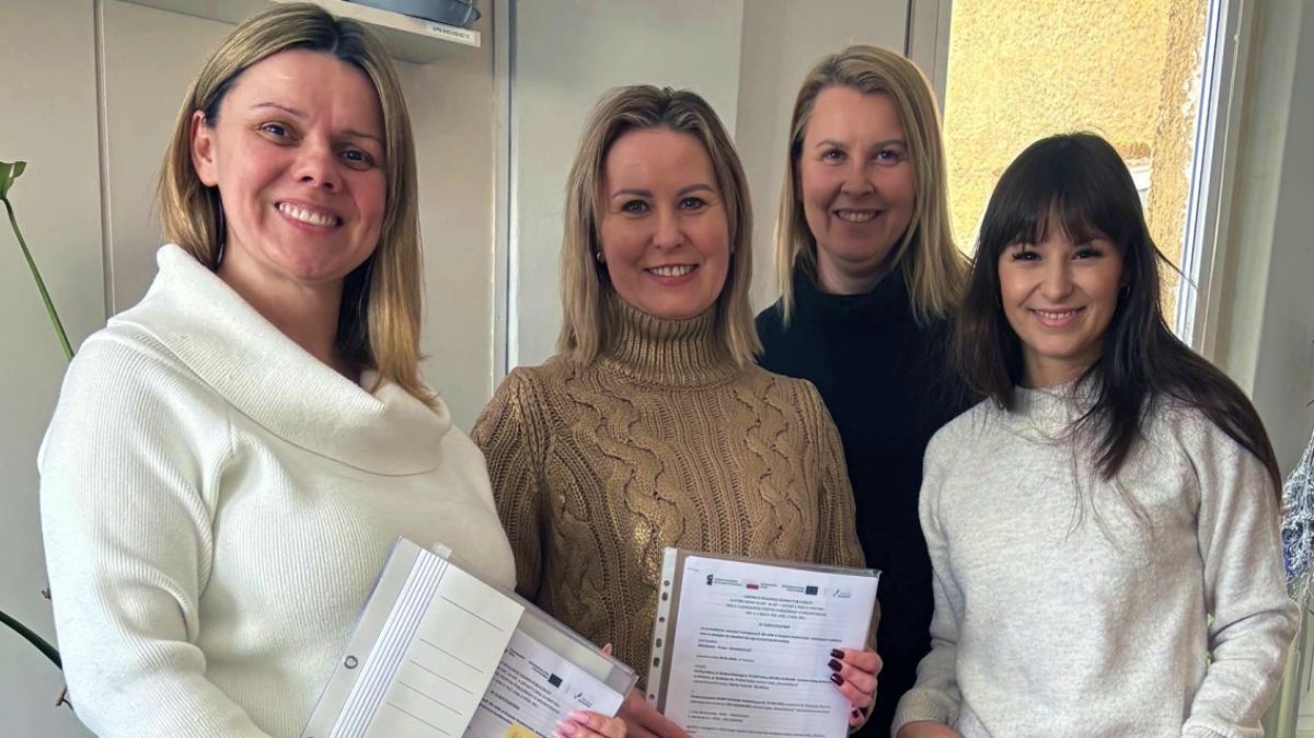 Czter osoby na zdjęciu z dokumentami w ręku