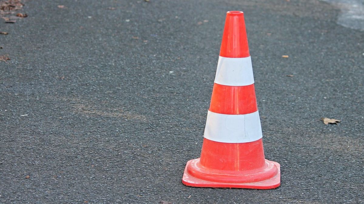 pachołek drogowy stojący na asfalcie