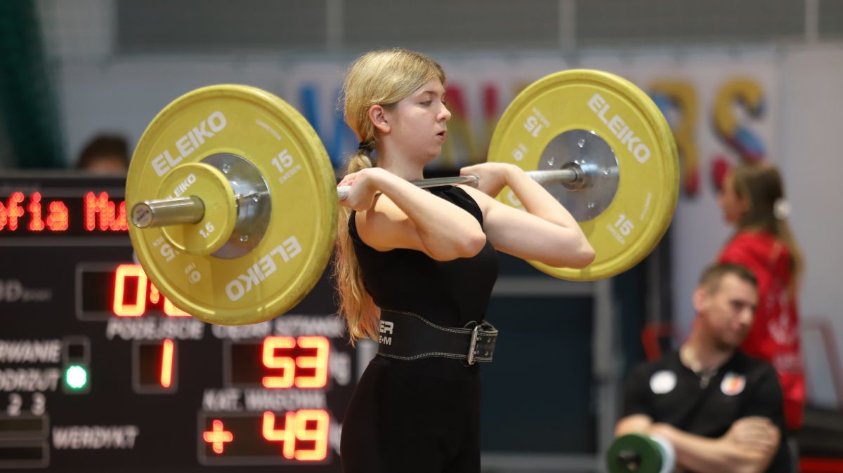 Młoda zawodniczka podnosząca sztangę.
