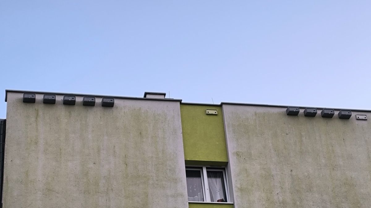 Kawałek ściany budynku z przymocowanymi budkami dla jerzyków