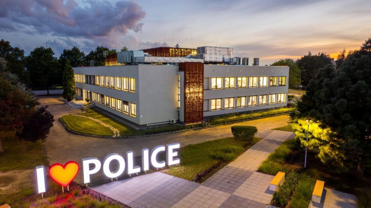 Na pierwszym planie neon ILOVEPOLICE, w tle budynek Miejskiego Ośrodka Kultury