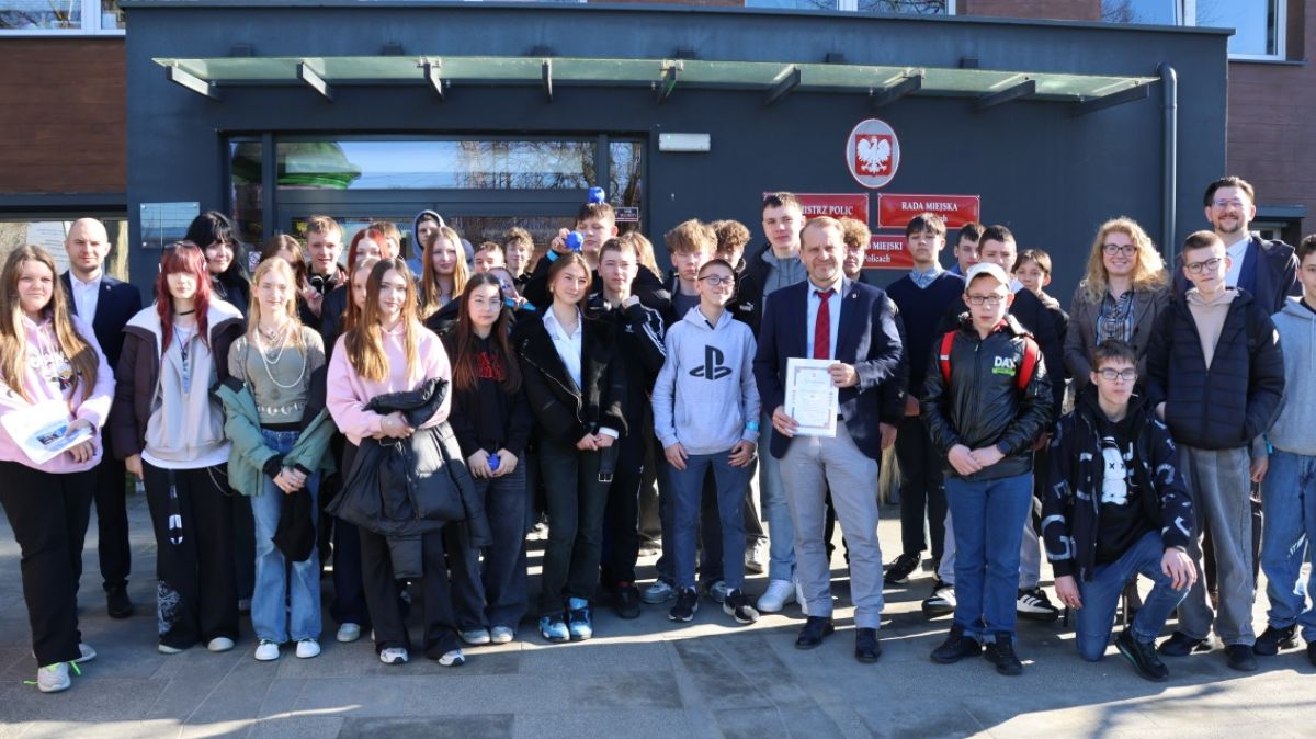 Wspólne zdjęcie uczniów z władzami gminy przed budynkiem Urzędu Miejskiego w Policach