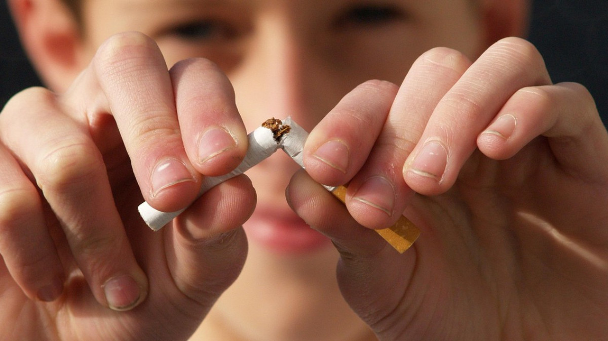 młody chłopak łamie papierosa