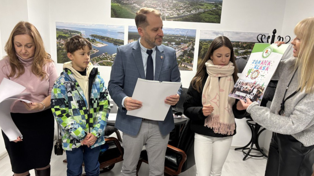 Troje dorosłych i dwoje uczniów - jedna osoba pokazuje kalendarz