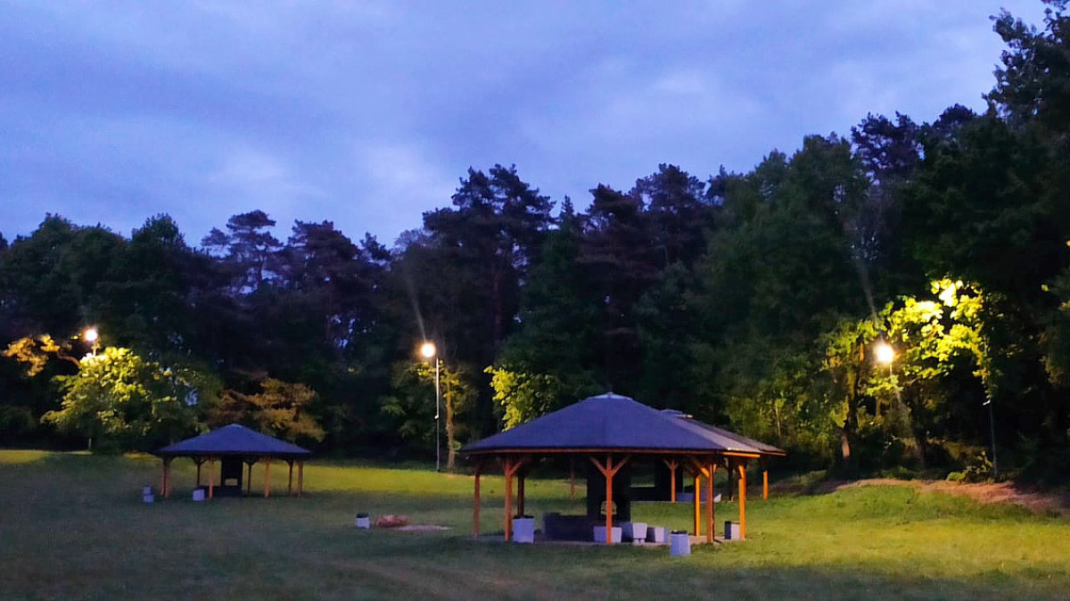 Polana, widoczne wiaty i piknikowe i działające oświetlenie