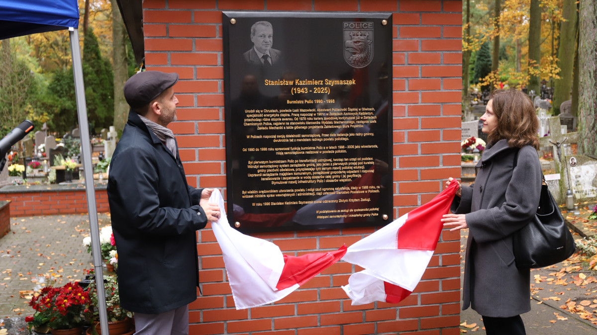 Burmistrz z córką i wnukiem Stanisława Szymaszka na tle tablicy