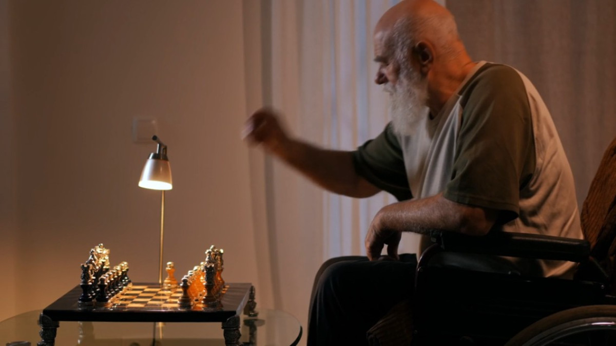 mężczyzna na wózku grający sam w szachy