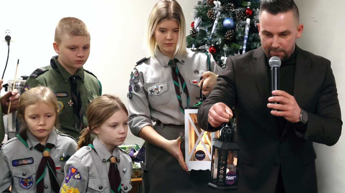 Przewodniczący Rady Miejskiej w Policach Artur Echaust odbiera od harcerzy Betlejemskie Światełko Pokoju